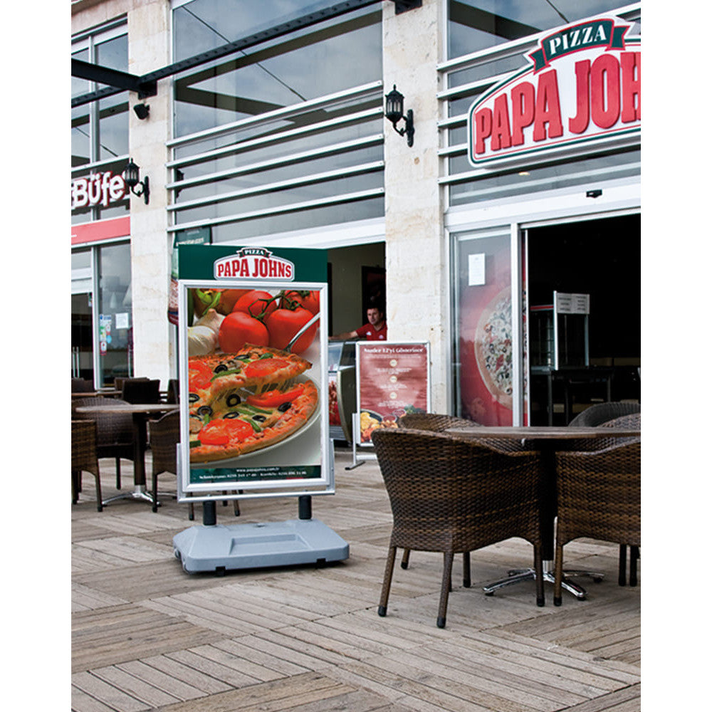 Massiver und windfester Strassenständer platziert in einem Restaurant im Aussenbereich mit Plakaten am POS